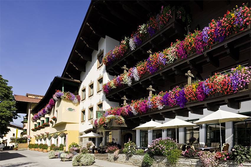 Mit bunten Blumen geschmückte Balkone am Hotel Kirchenwirt in Reith im Alpbachtal